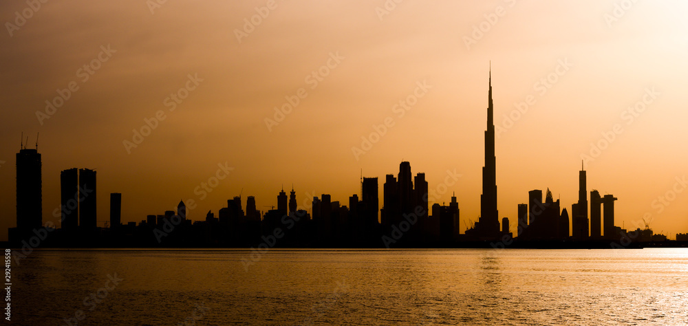 Stunning view of the silhouette of the Dubai skyline during a beautiful and dramatic sunset. Dubai is the largest and most populous city in the United Arab Emirates (UAE)