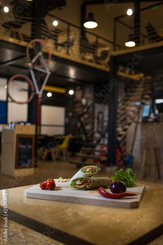 Appetizing fast food on a wooden board with fresh vegetables. photo