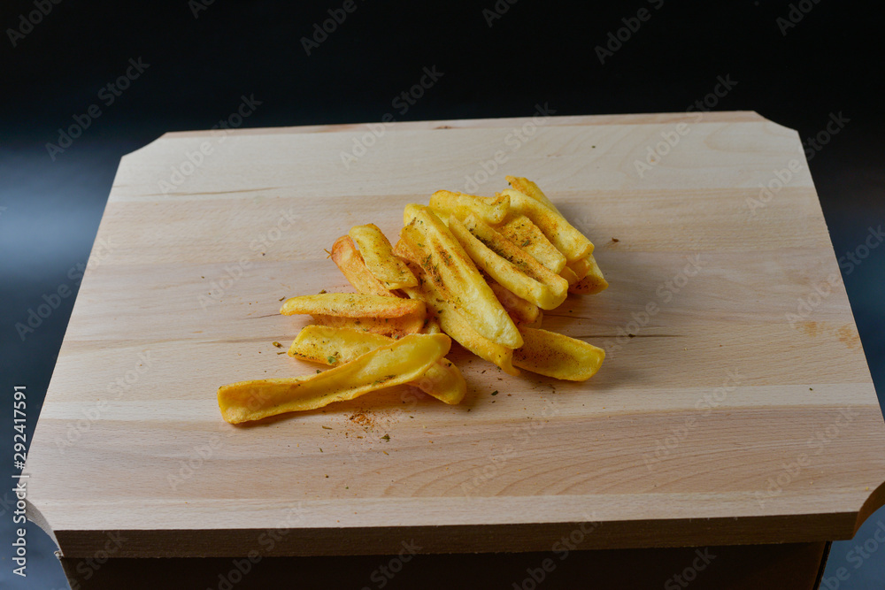 French fries on a wooden board isolated on black French fries on a wooden board isolated on black