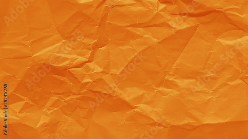 Orange color crumpled sheet of paper texture. Wrinkled abstract background