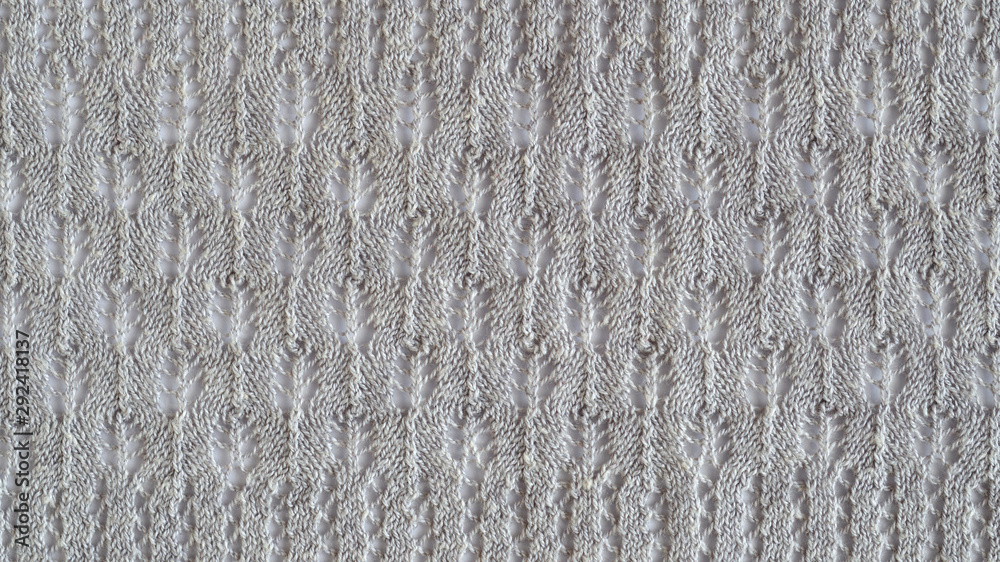 Lace stitch pattern with leaves on white backround. Neutral gray color knitted texture. Closeup Lace stitch pattern with leaves on white backround. Neutral gray color knitted texture. Closeup