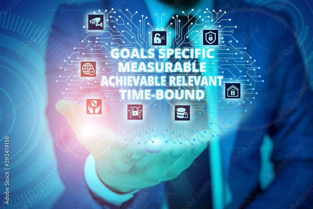 Conceptual hand writing showing Goals Specif Measureable AC. Concept meaning Goals Specific Measurable Achievable Relevant Time Bound Male wear formal suit presenting presentation smart device