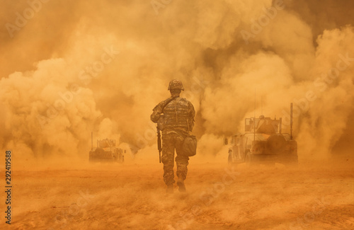 Military troops and helicopter on the way to the battlefield between sand storm in desert photo