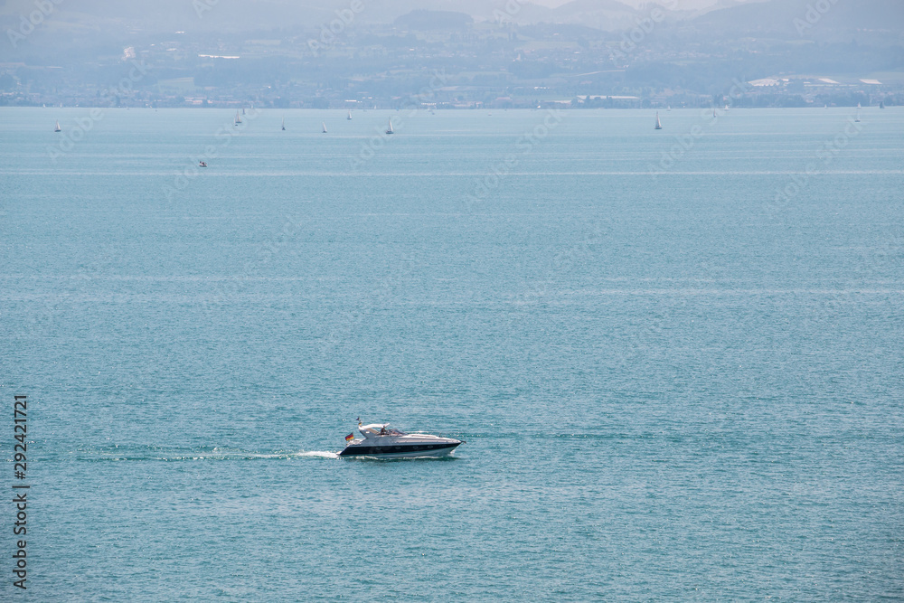 Motorboat and other sailboats with white sails on the lake Motorboat and other sailboats with white sails on the lake