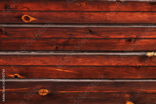 Stained natural wood plank texture background. Dark brown. Closeup