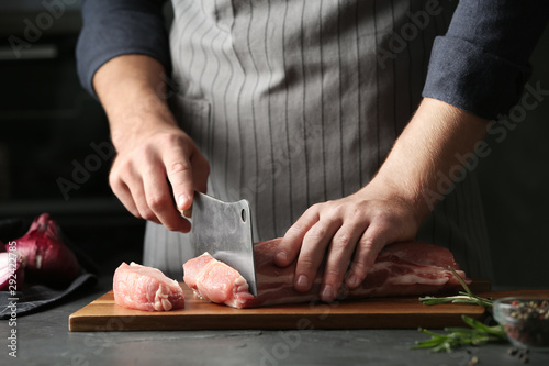 Fototapeta Naklejka Na Ścianę i Meble -  Man cutting fresh raw meat on grey table, closeup