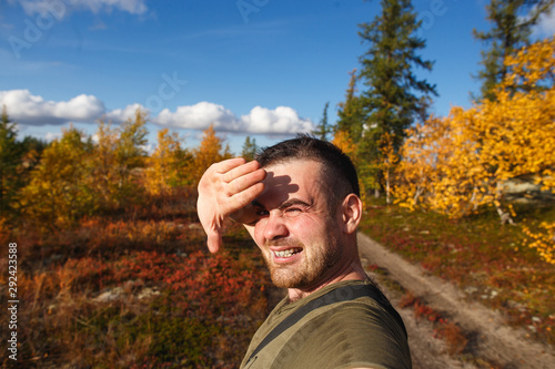 Handsome man hiker touring in autumn tundra.