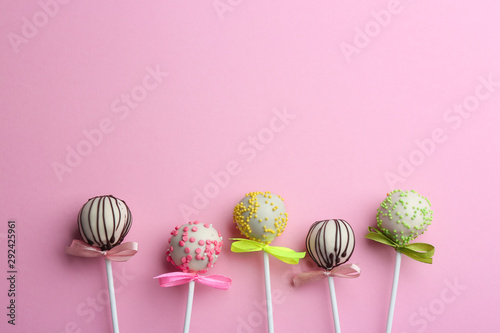 Different tasty cake pops on light pink background, flat lay. Space for text © New Africa