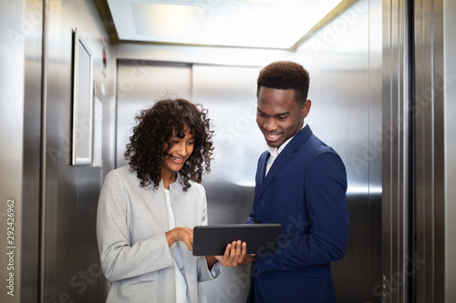 Businesspeople Discussing Standing Inside Elevator photo