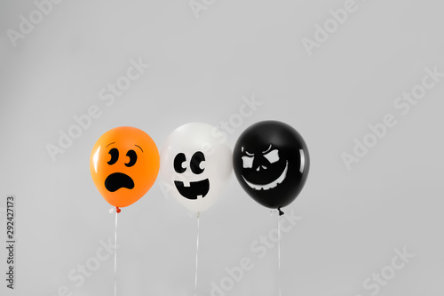 Spooky balloons for Halloween party on light grey background