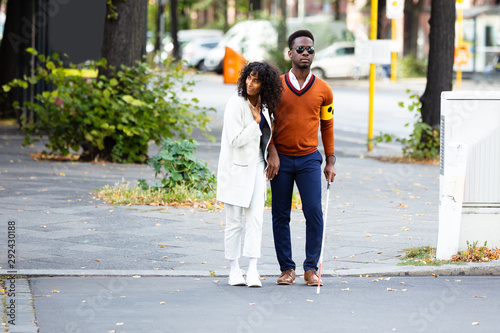 Woman Assisting Blind Man On Street