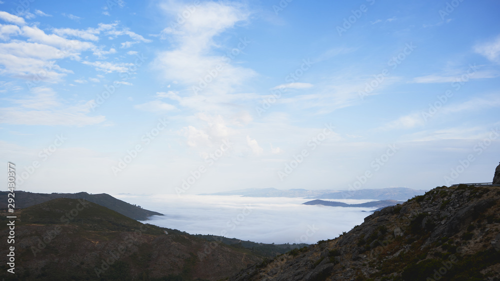 Panorama of fog on the mountains. Blue sky on background  