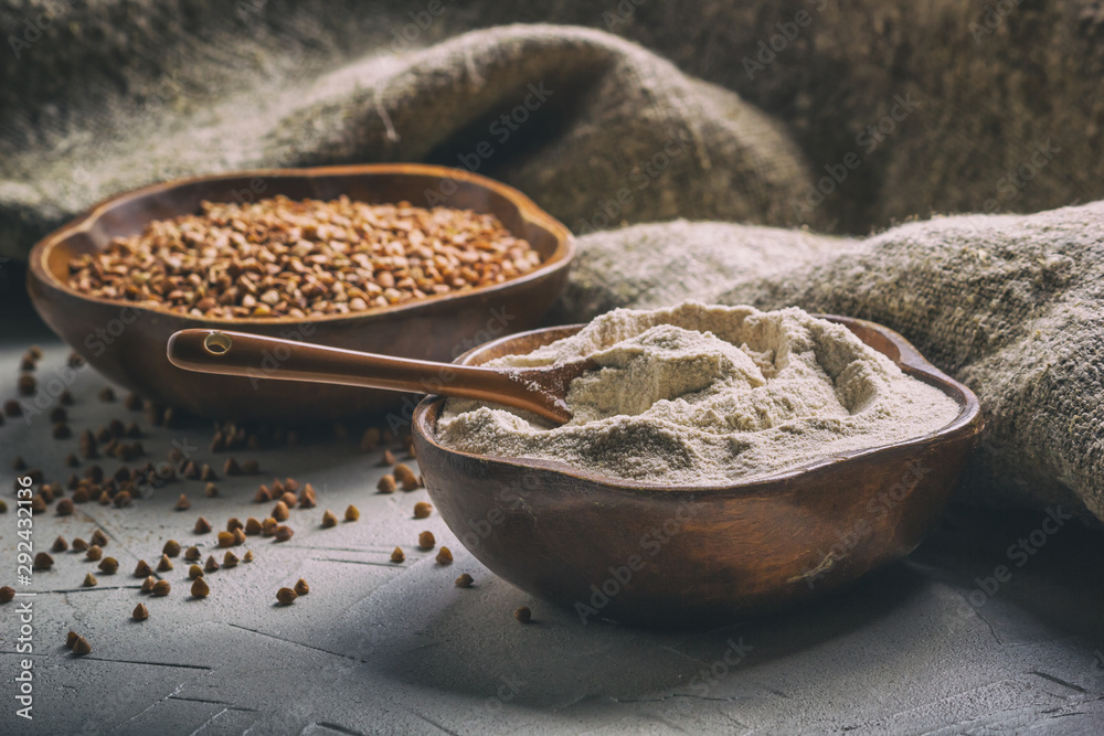 Rural still-life - the buckwheat flour and the peeled groats of buckwheat (Fagopyrum esculentum) on the background of burlap, closeup with selective focus Rural still-life - the buckwheat flour and the peeled groats of buckwheat (Fagopyrum esculentum) on the background of burlap, closeup with selective focus