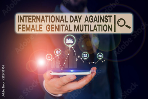 Conceptual hand writing showing International Day Against. Concept meaning International Day Against Female Genital Mutilation Male wear formal suit presenting presentation smart device