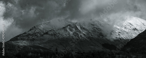 Black and White landscape. View towards Ballachulish across Loch Linnhe from Ardgour. Highlands of Scotland, with snow on the mountains and low hanging clouds with spots of sun breaking through. UK