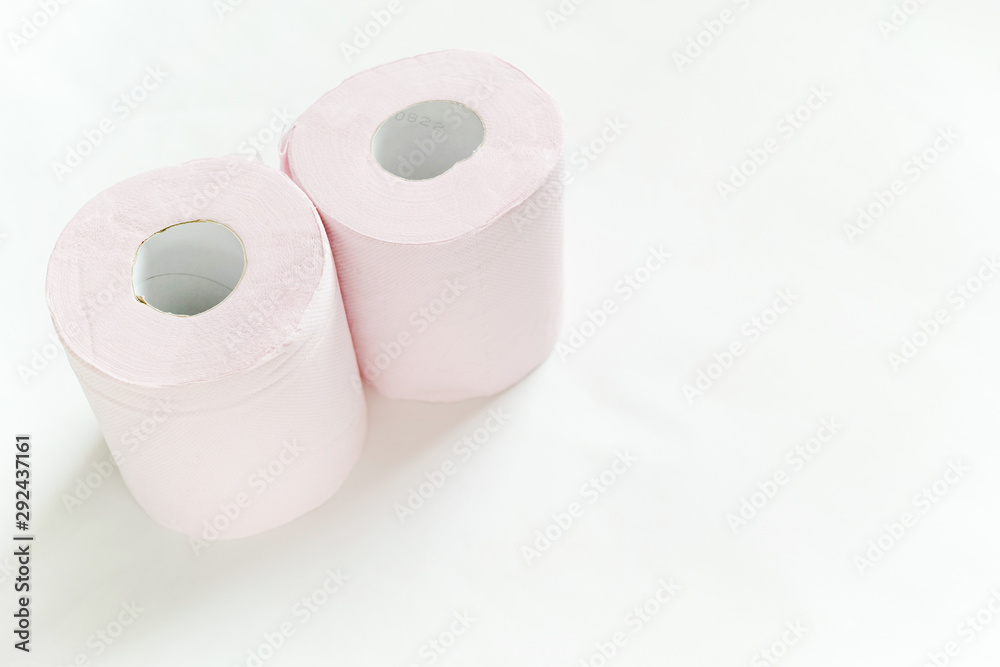 白バックの左寄りに置いてある二つのピンクの新品のトイレットペーパー 白バックの左寄りに置いてある二つのピンクの新品のトイレットペーパー
