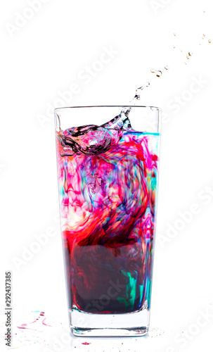 Color that drips into a glass of water on a white background
