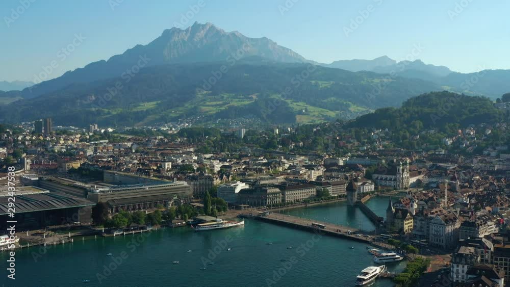 sunny evening flight over luzern cityscape train station lakeside bridge bay aerial panorama 4k switzerland