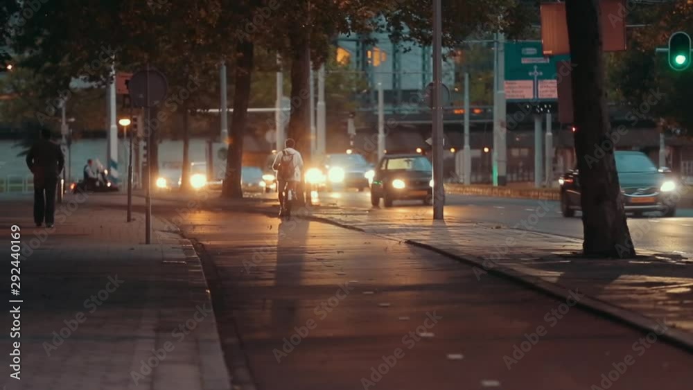 Kazakhstan. Almaty. July 2017. A cyclist uses his bike in the urban area. Back view of a man in white clothes riding back home after working day. Kazakhstan. Almaty. July 2017. A cyclist uses his bike in the urban area. Back view of a man in white clothes riding back home after working day.