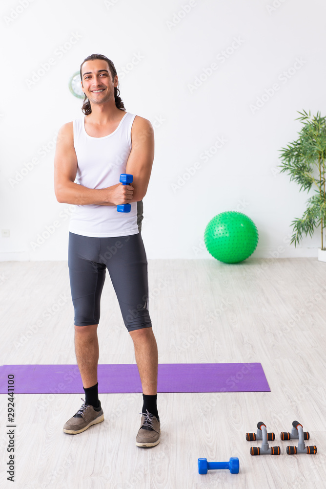 Young handsome man doing sport exercises indoors Young handsome man doing sport exercises indoors