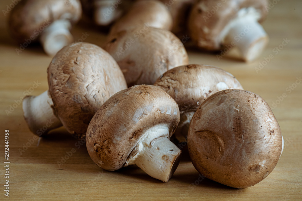 Close up of white mushrooms on a wooden table tap. Close up of white mushrooms on a wooden table tap.