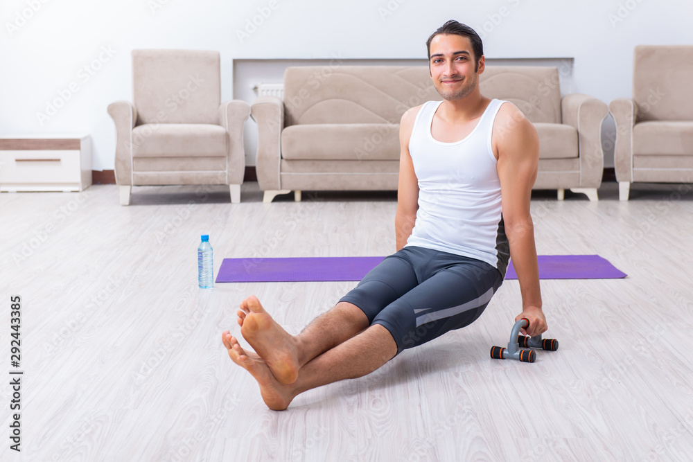 Fototapeta premium Young man training and exercising at home