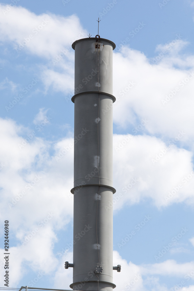 metal factory smokestack on a cloudy sky