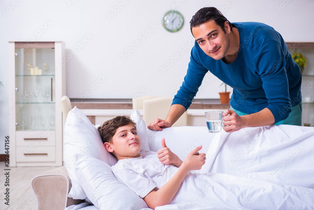 Obraz premium Young father caring for sick son