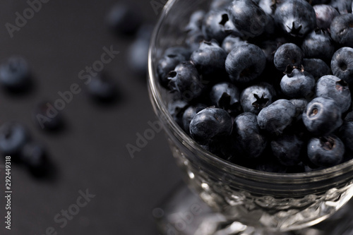 Crystal dessert cup full of blueberries on dark background