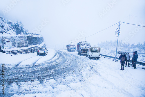 Canvas Print Trees, highway road and vehicle covered with white snow - Image