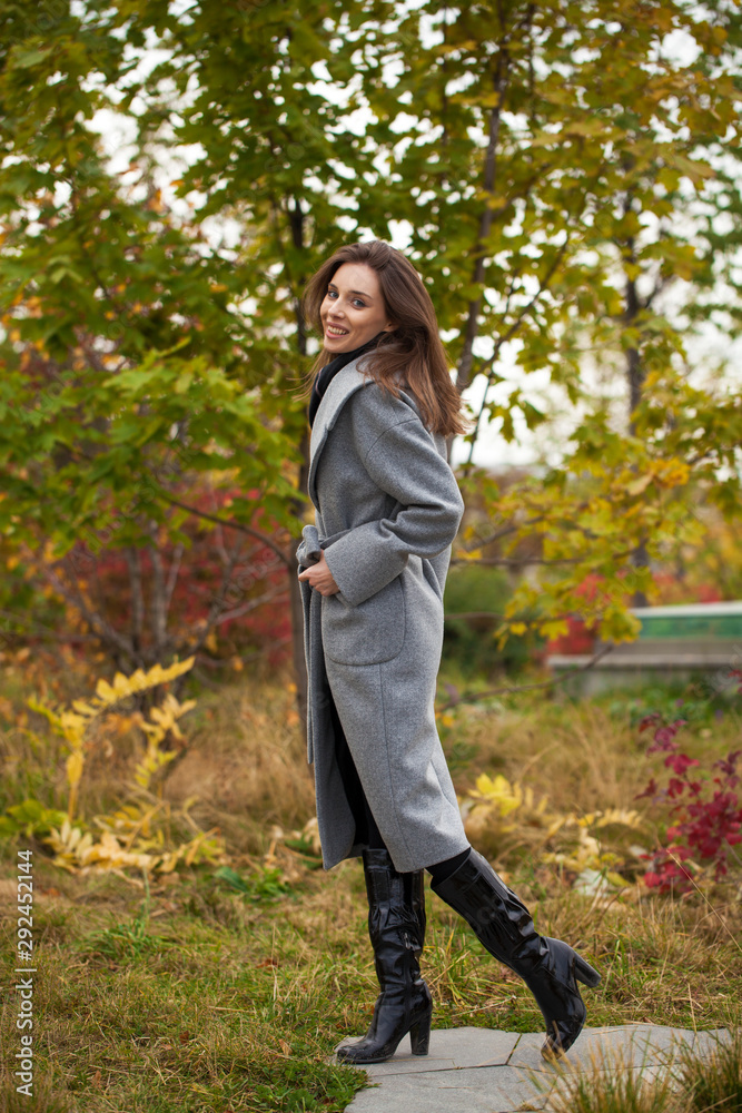Portrait of young beautiful woman in gray coat posing in autumn park in Moscow Portrait of young beautiful woman in gray coat posing in autumn park in Moscow
