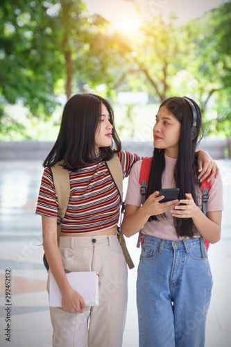 Asian university students chating, talking in university campus. Female university students talking, studying and exchanging together in university campus. Education and life style concept.