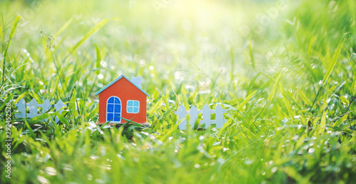 Orange house model on green grass.