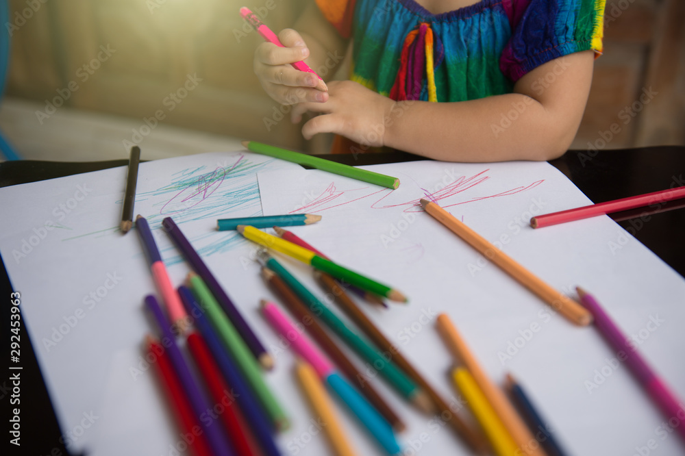 little girl learn to draw and paint with various pencil colour and white paper on wooden desk, family relationship concept, home school, holding pencil colour little girl learn to draw and paint with various pencil colour and white paper on wooden desk, family relationship concept, home school, holding pencil colour