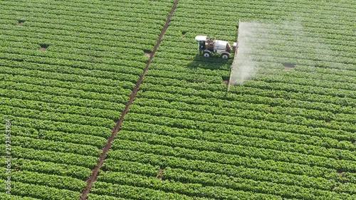 Pesticide Sprayer Tractor working on a Sugar Beet  field, Top down aerial follow footage. photo