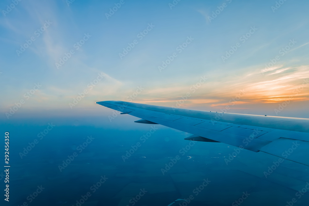 wing of airplane flying above clouds wing of airplane flying above clouds