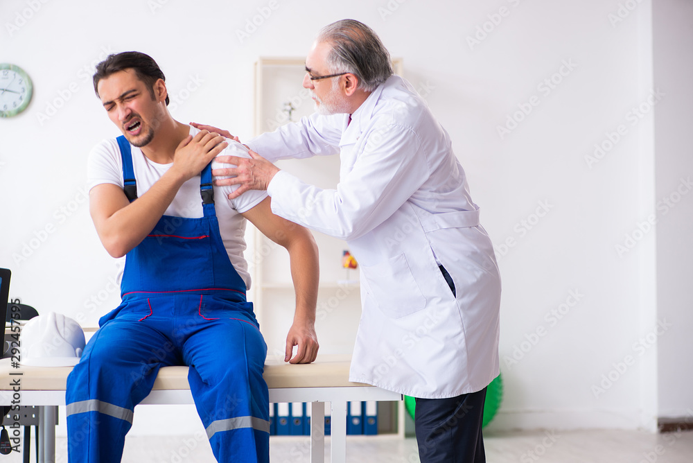 Fototapeta premium Young male contractor visiting old doctor