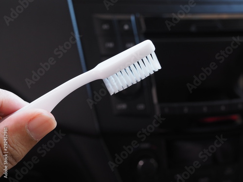 use toothbrush to cleaning and remove dust of air conditioner on panel console in car