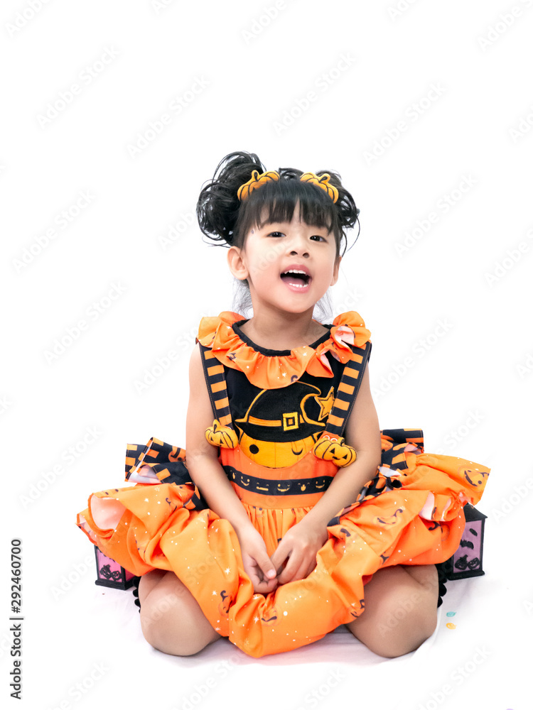 Asian children girl in pumpkin dress costume for Halloween decoration in white background Asian children girl in pumpkin dress costume for Halloween decoration in white background