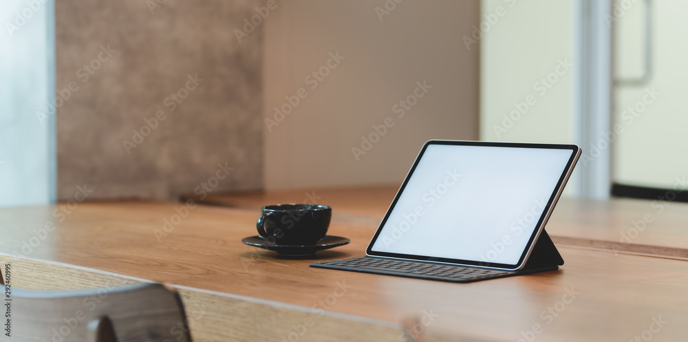 Blank screen tablet and a cup of coffee in comfortable workplace Blank screen tablet and a cup of coffee in comfortable workplace