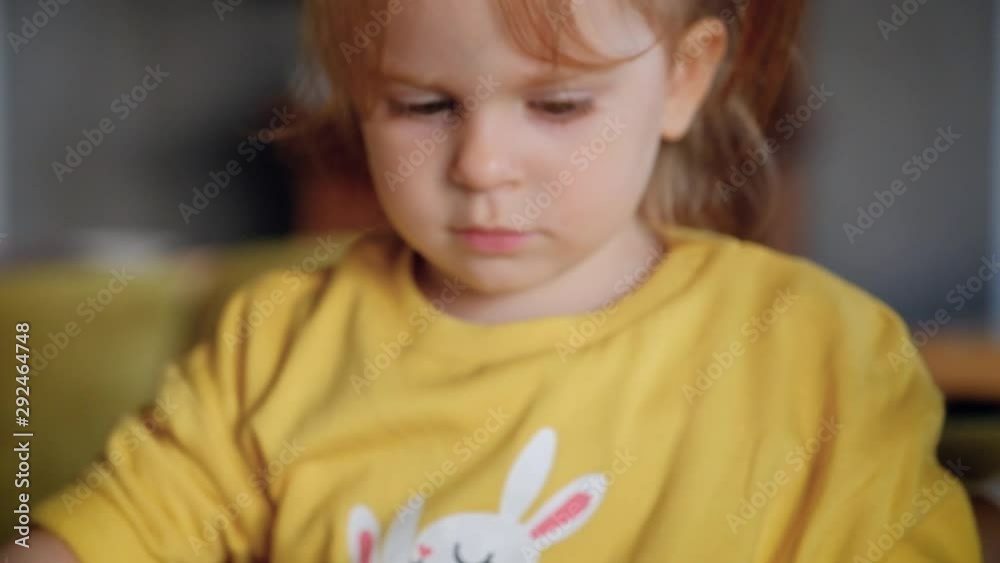 Close-up of a cute little girl draws sitting at a table with colored pencils Close-up of a cute little girl draws sitting at a table with colored pencils