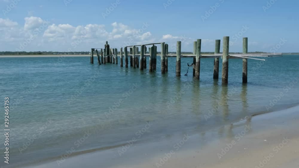 scenic view of the North Carolina Intracoastal Waterway at Topsail Island, NC. an abandoned wooden pier stands in the water scenic view of the North Carolina Intracoastal Waterway at Topsail Island, NC. an abandoned wooden pier stands in the water