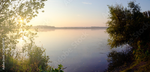 Beautiful sunny summer scene with sun rising over the lake © valeriy boyarskiy