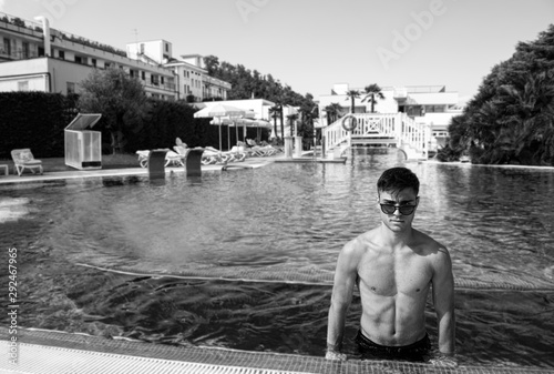 Photos Portrait of a young man on the edge of a swimming pool in the thermal hotel in Abano Terme
