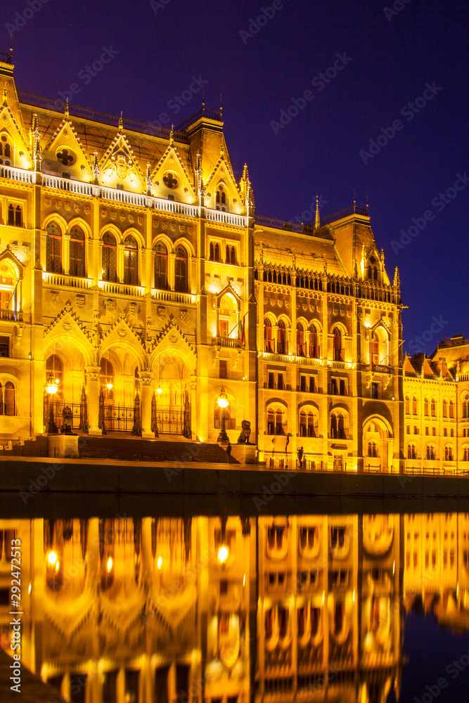 Hungarian Parliament building illuminated at night with reflection