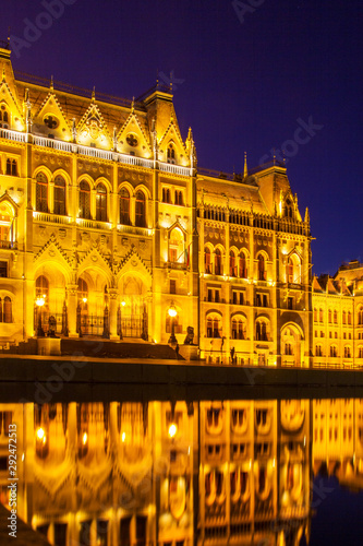 Hungarian Parliament building illuminated at night with reflection