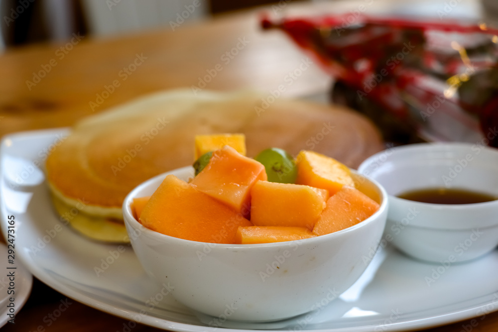 Sliced papaya and grapes with pan cake served as breakfast Sliced papaya and grapes with pan cake served as breakfast