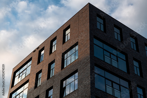 Golden light hitting one side of a building on a cloudy day © Mark