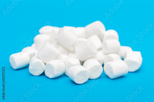 Heap of small marshmallow on blue.