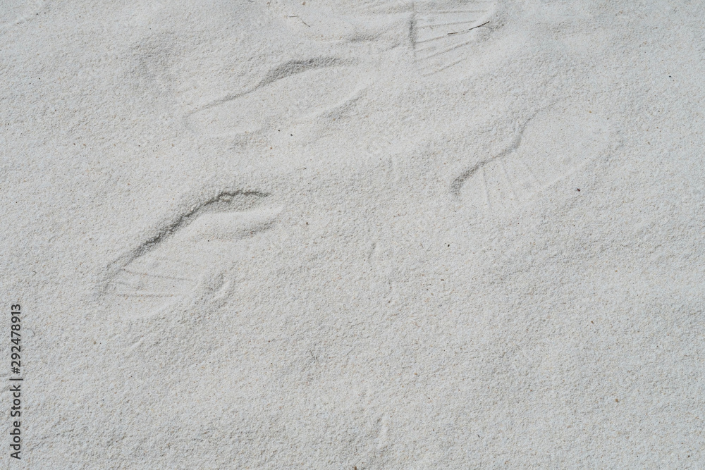 Sand texture background, natural sand at the beach, soft white with shoe marks walking on the sand Sand texture background, natural sand at the beach, soft white with shoe marks walking on the sand